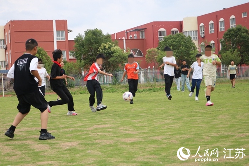 課后，東東（左五）與同學踢球。人民網記者 馬曉波攝